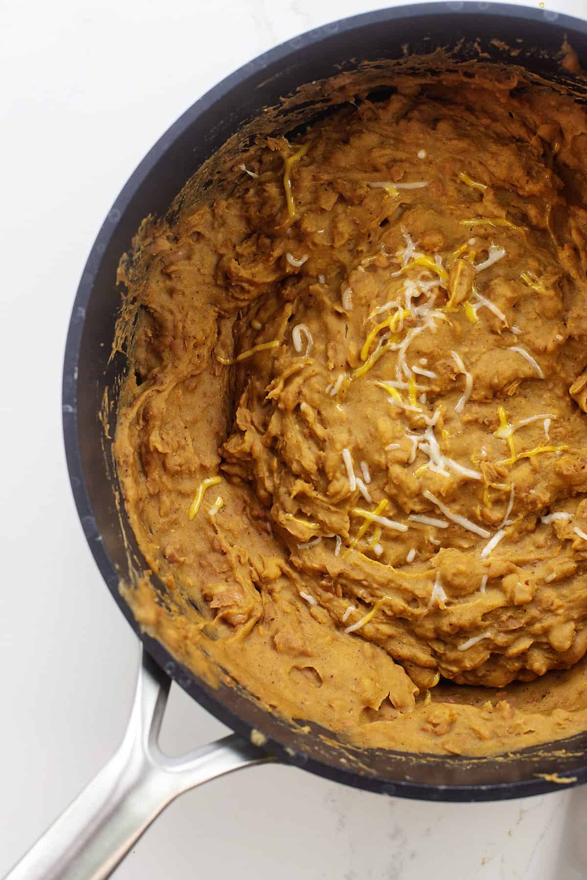 Refried beans in black skillet.