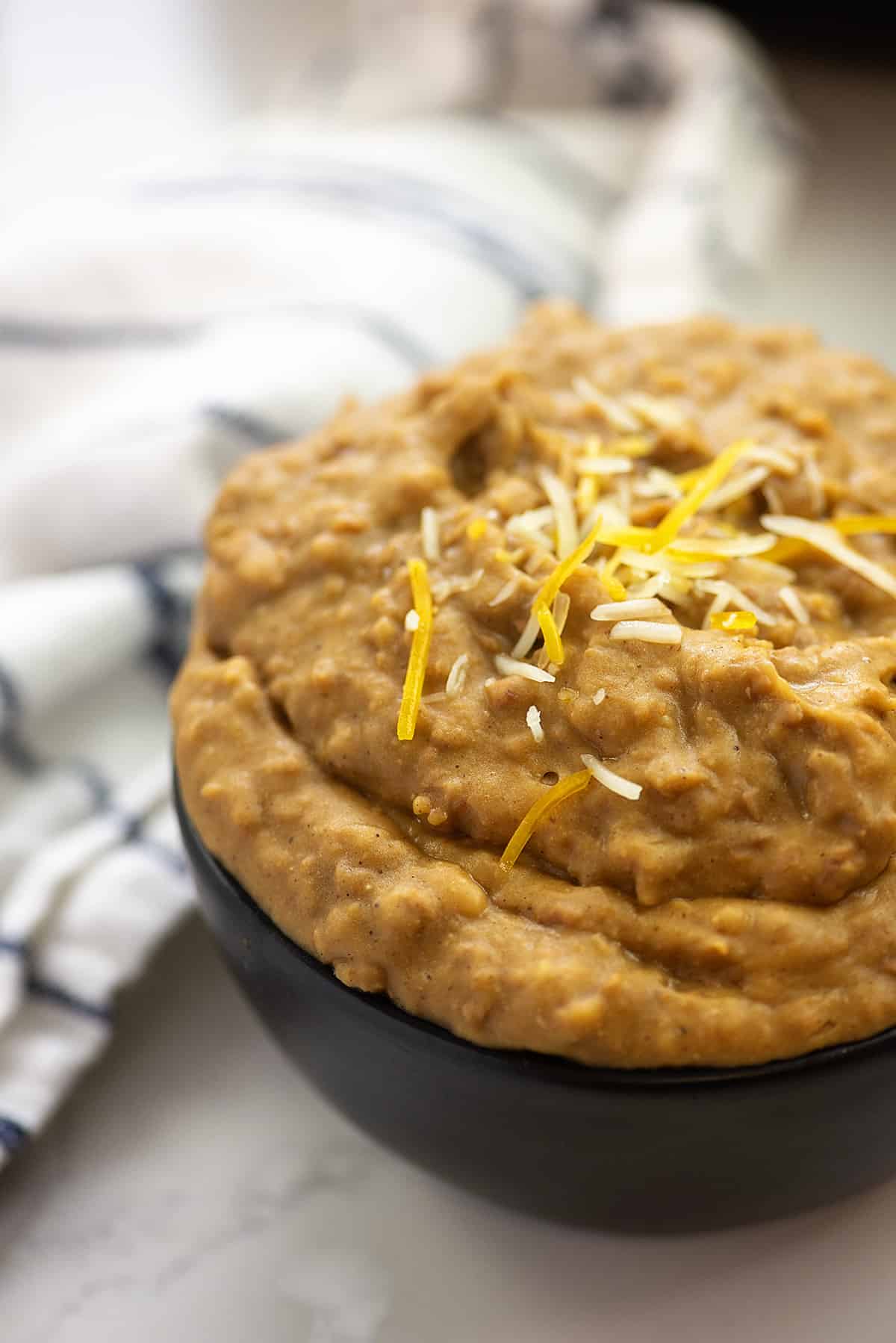 Black bowl filled with refried beans.