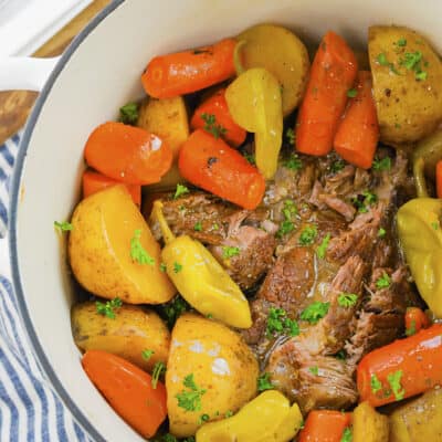 Overhead view of Mississippi pot roast with carrots and potatoes in dutch oven.