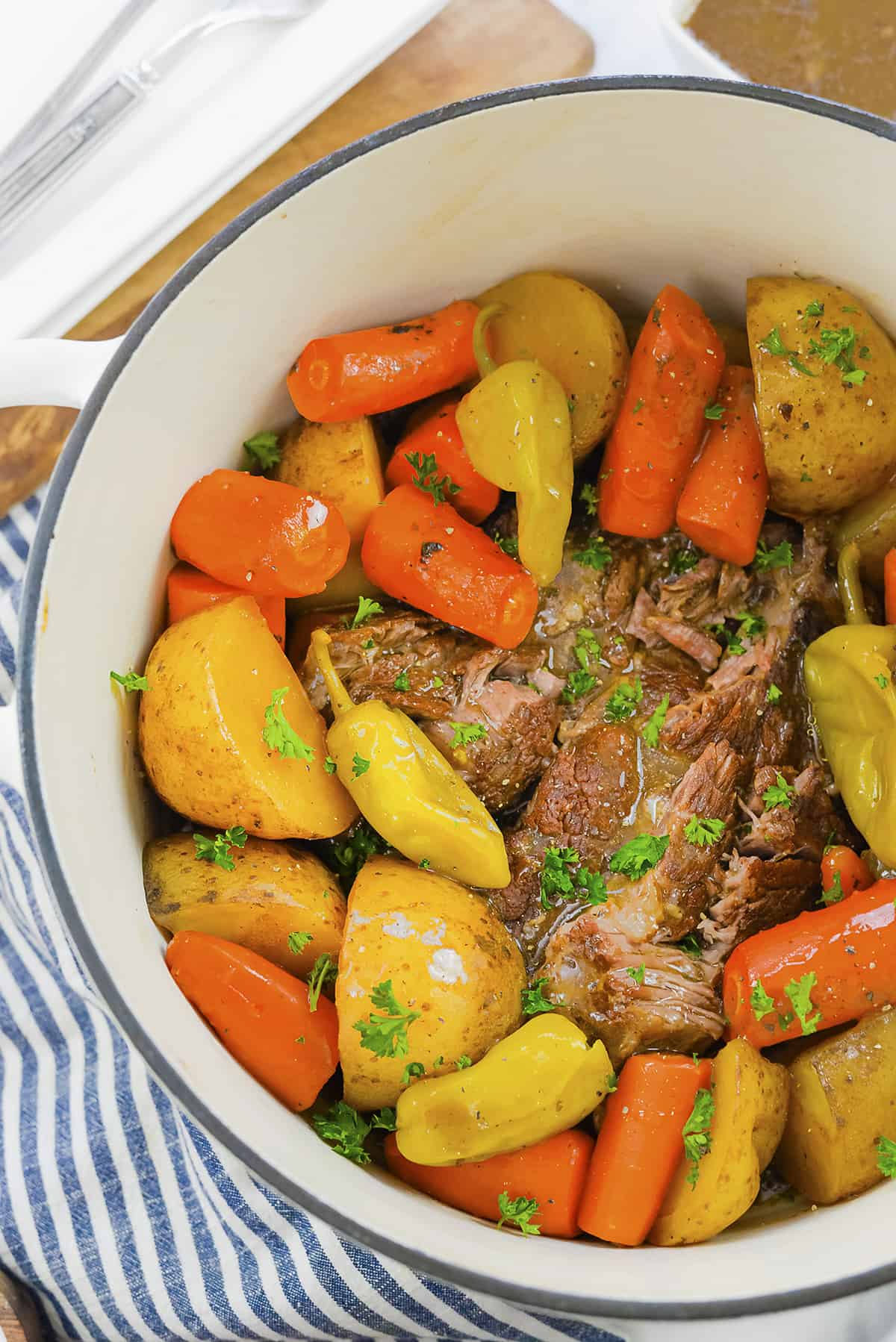 Overhead view of Mississippi pot roast with carrots and potatoes in dutch oven.