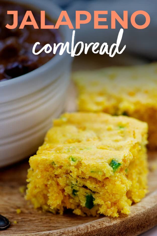 Slice of cheddar jalapeno cornbread on wooden board.