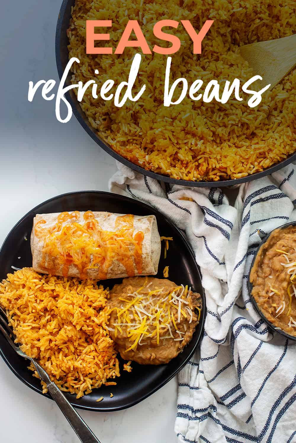 Overhead view of easy refried beans recipe on black plate with rice and burrito.