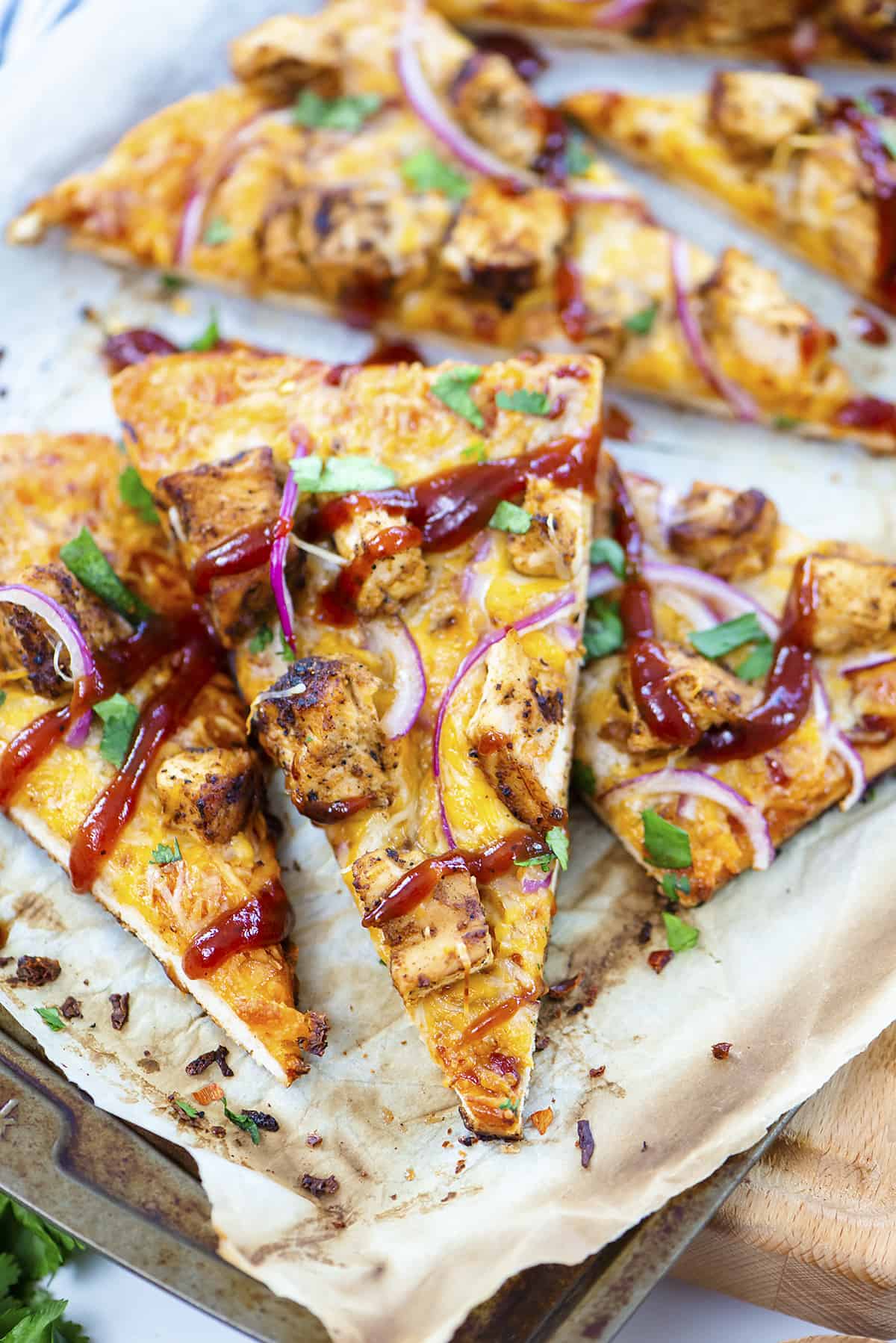 Sliced BBQ chicken flatbread on baking sheet.