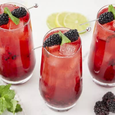 Mojitos made with mint and blackberries in glasses.