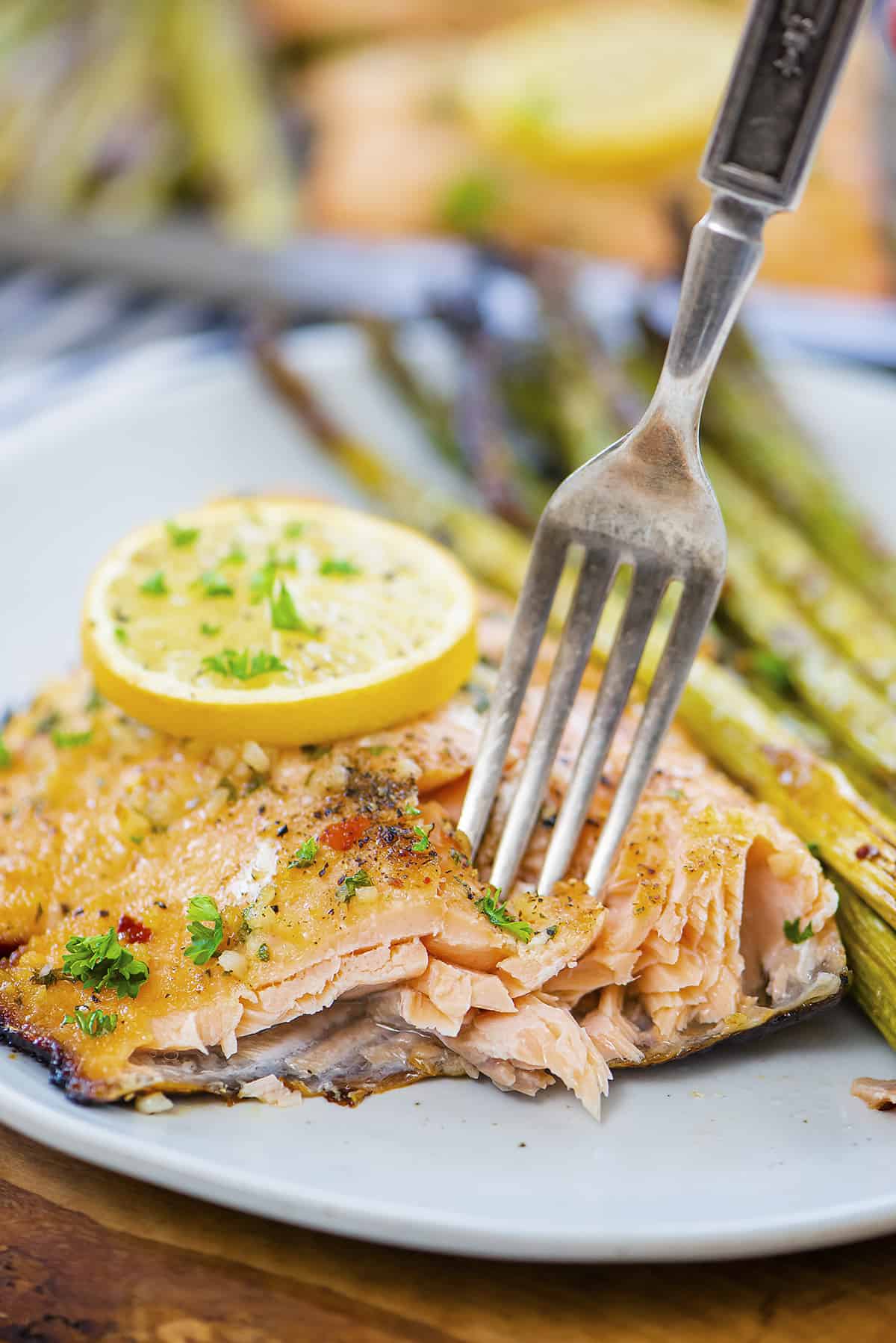 Piece of salmon on plate with a fork.
