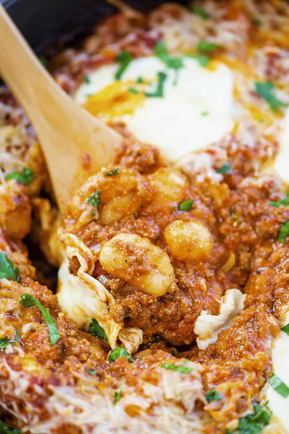 Skillet full of baked gnocchi with cheese.