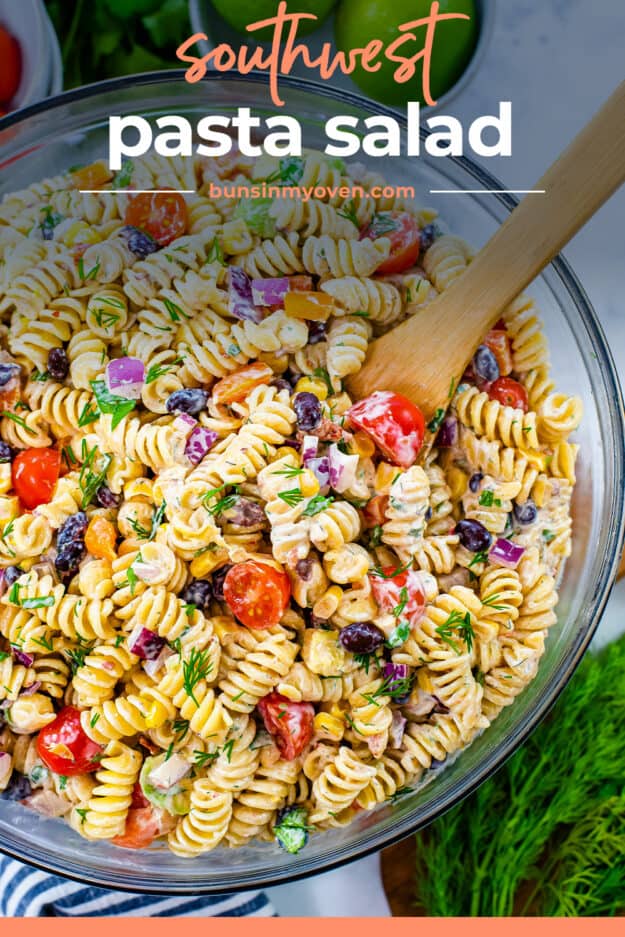 Wooden spoon in bowl of pasta salad.