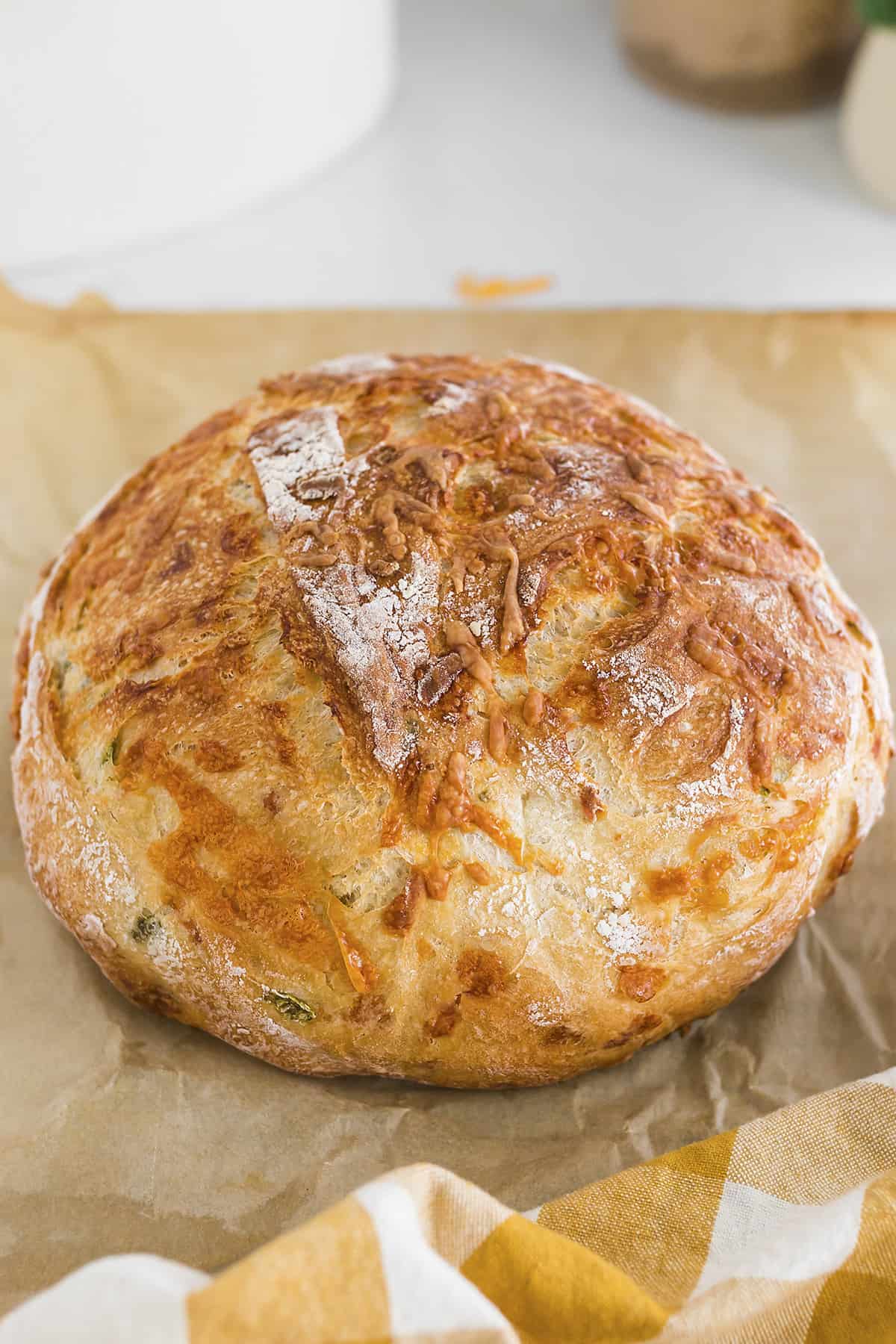 Loaf of dutch oven bread on parchment.