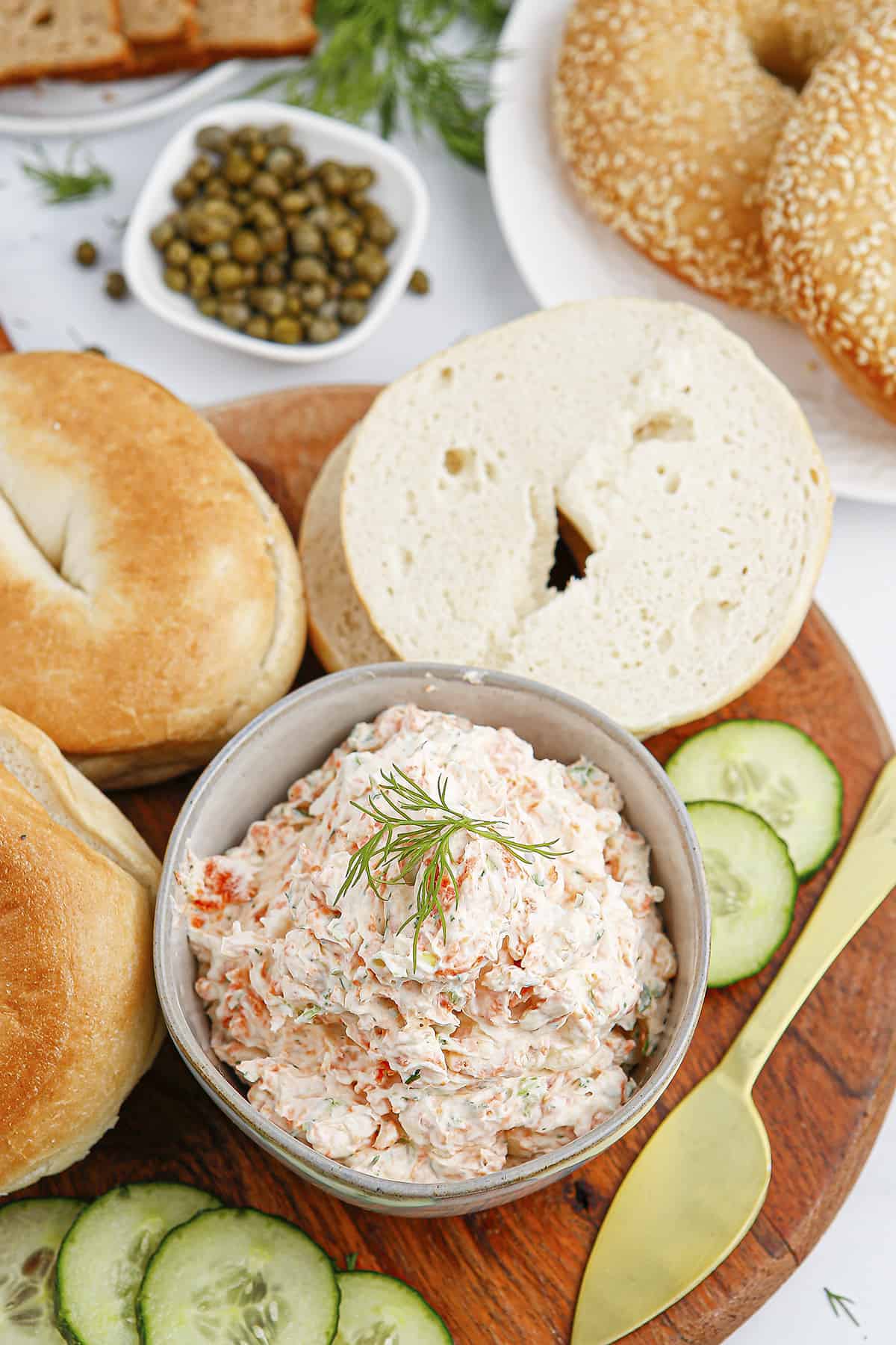 Smoked salmon cream cheese in bowl surrounded by bagels.