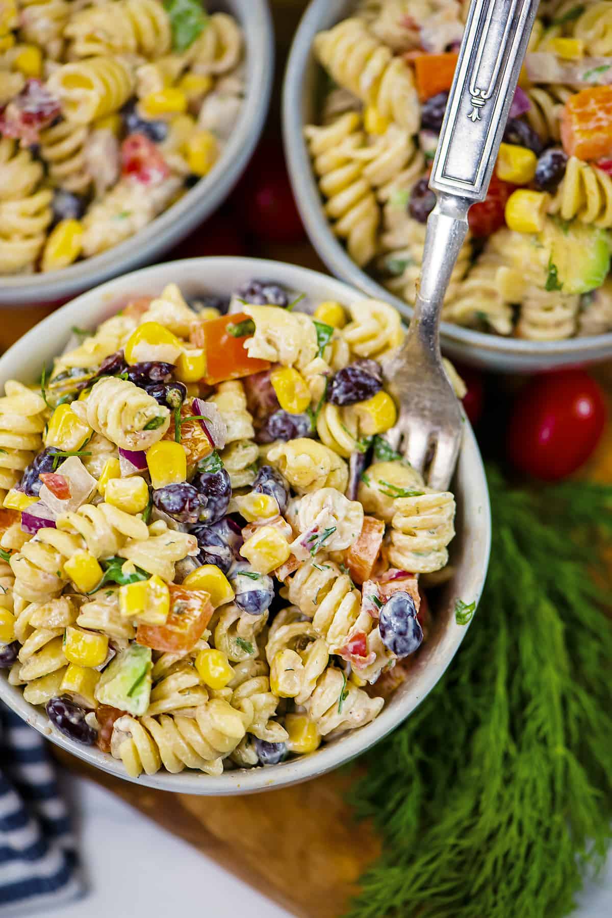 Pasta salad in white bowl with fork.