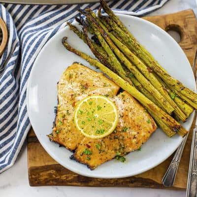 Baked salmon and asparagus on white plate.