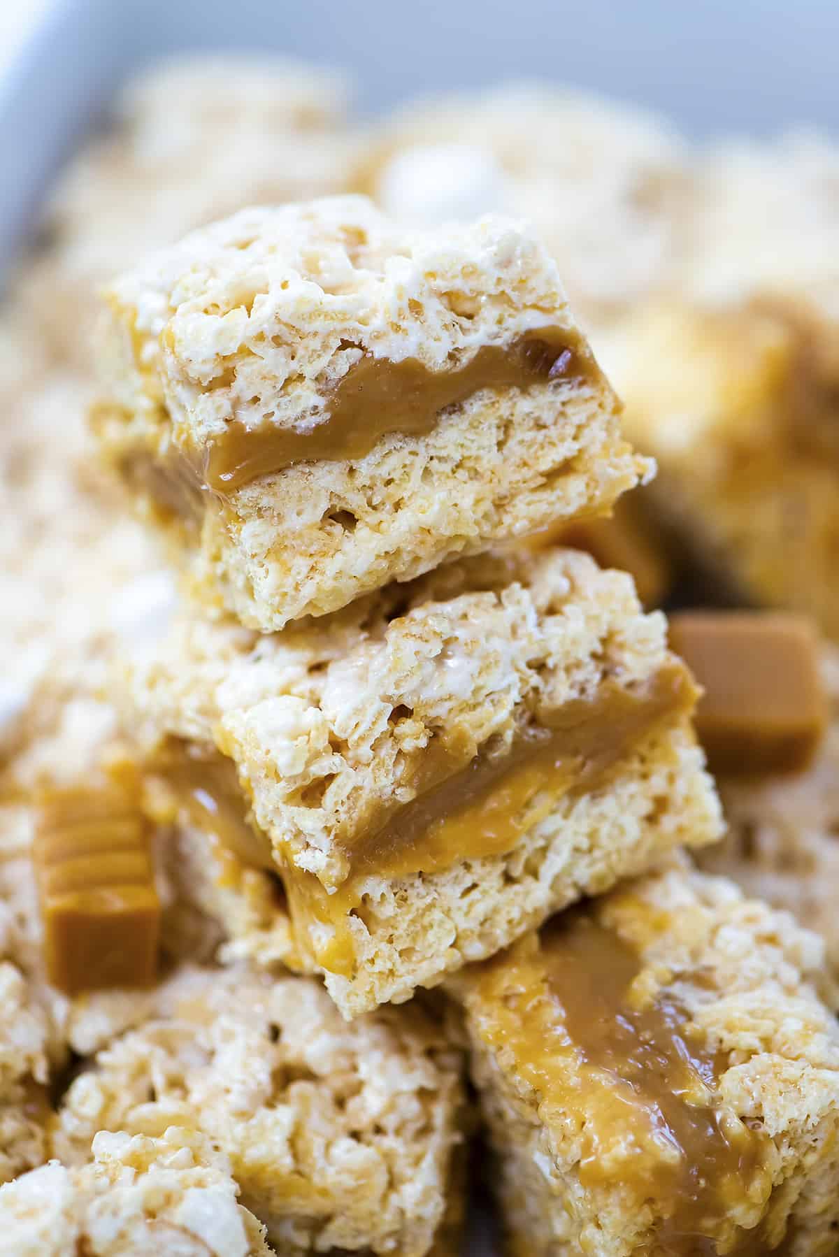 Rice krispies treats filled with caramel and stacked together.