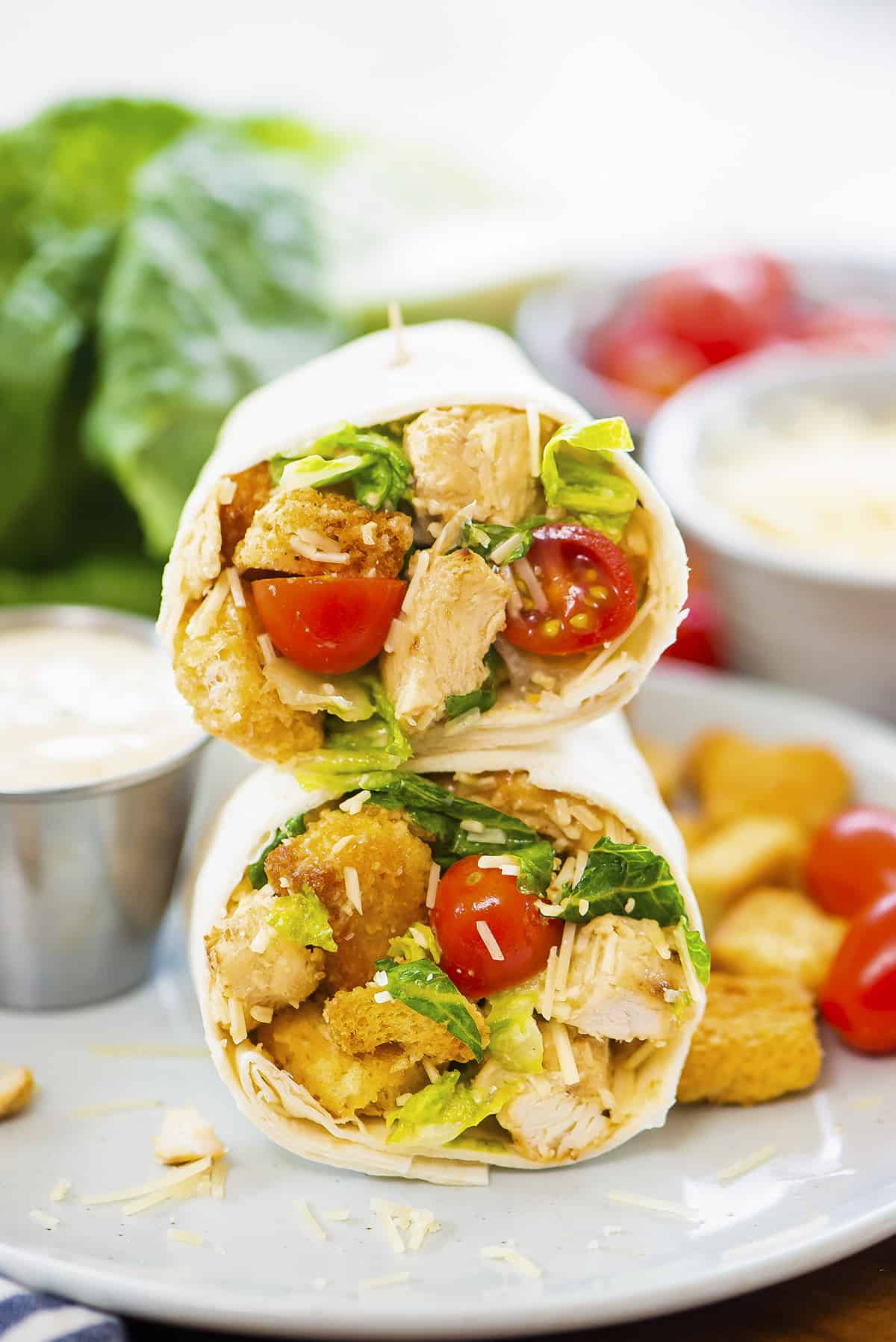 Stack of chicken caesar wraps on small plate.