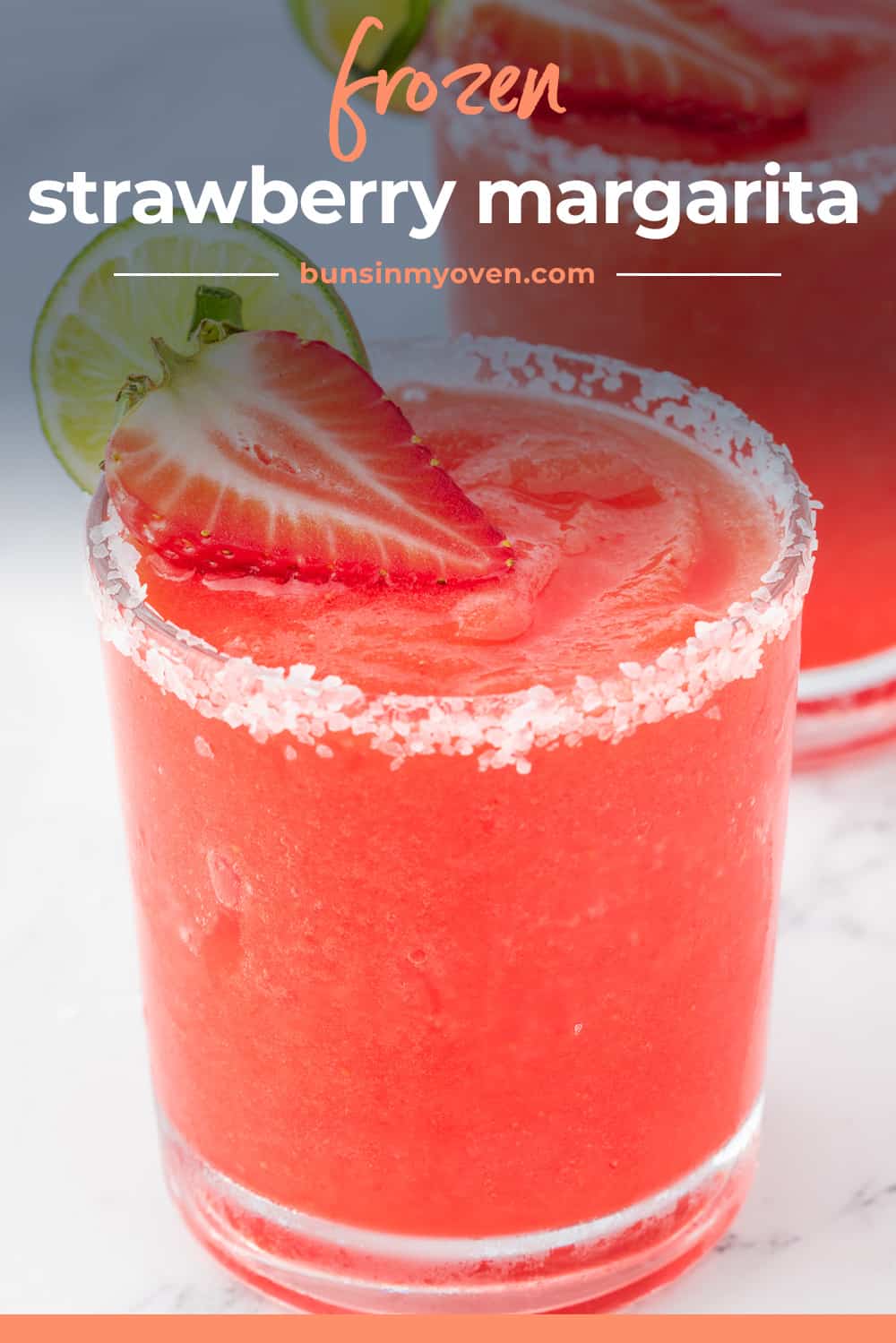 Frozen strawberry margarita in glass with fresh berry.