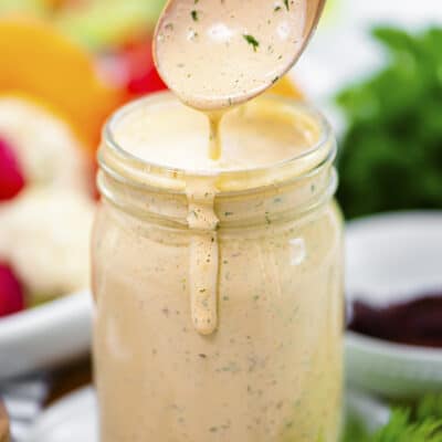 Spoonful of chipotle ranch dressing over jar.