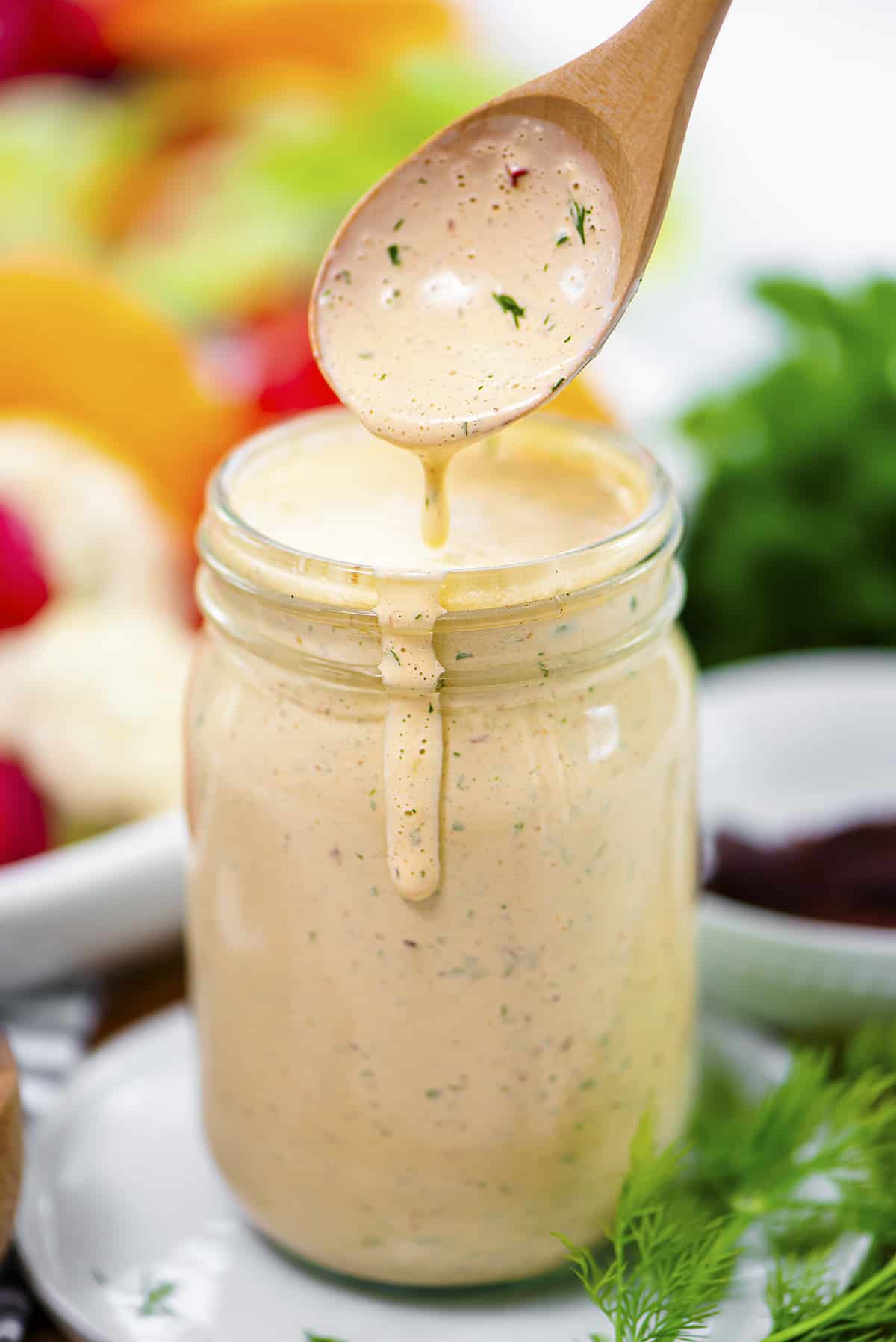 Spoonful of chipotle ranch dressing over jar.