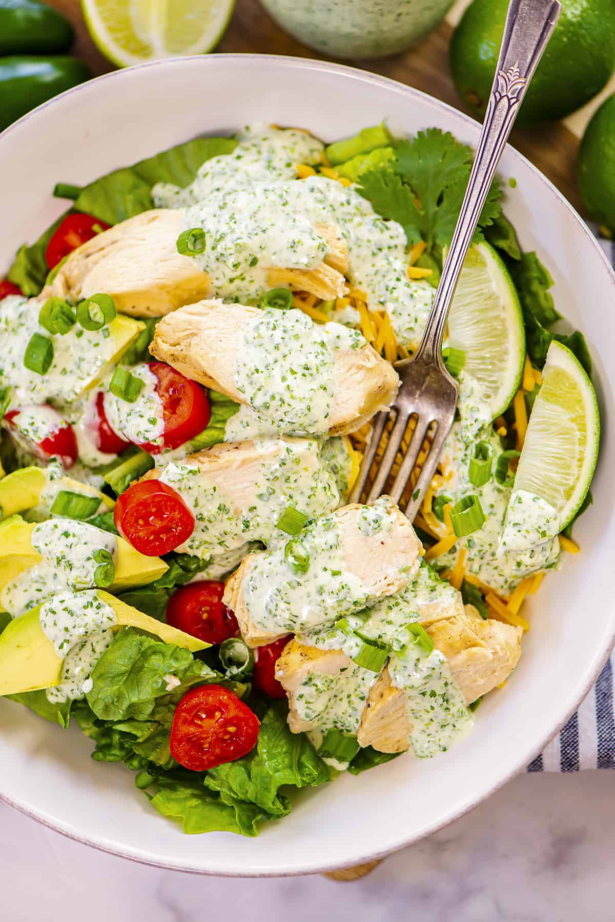 Garden salad topped with chicken and cilantro lime salad dressing.