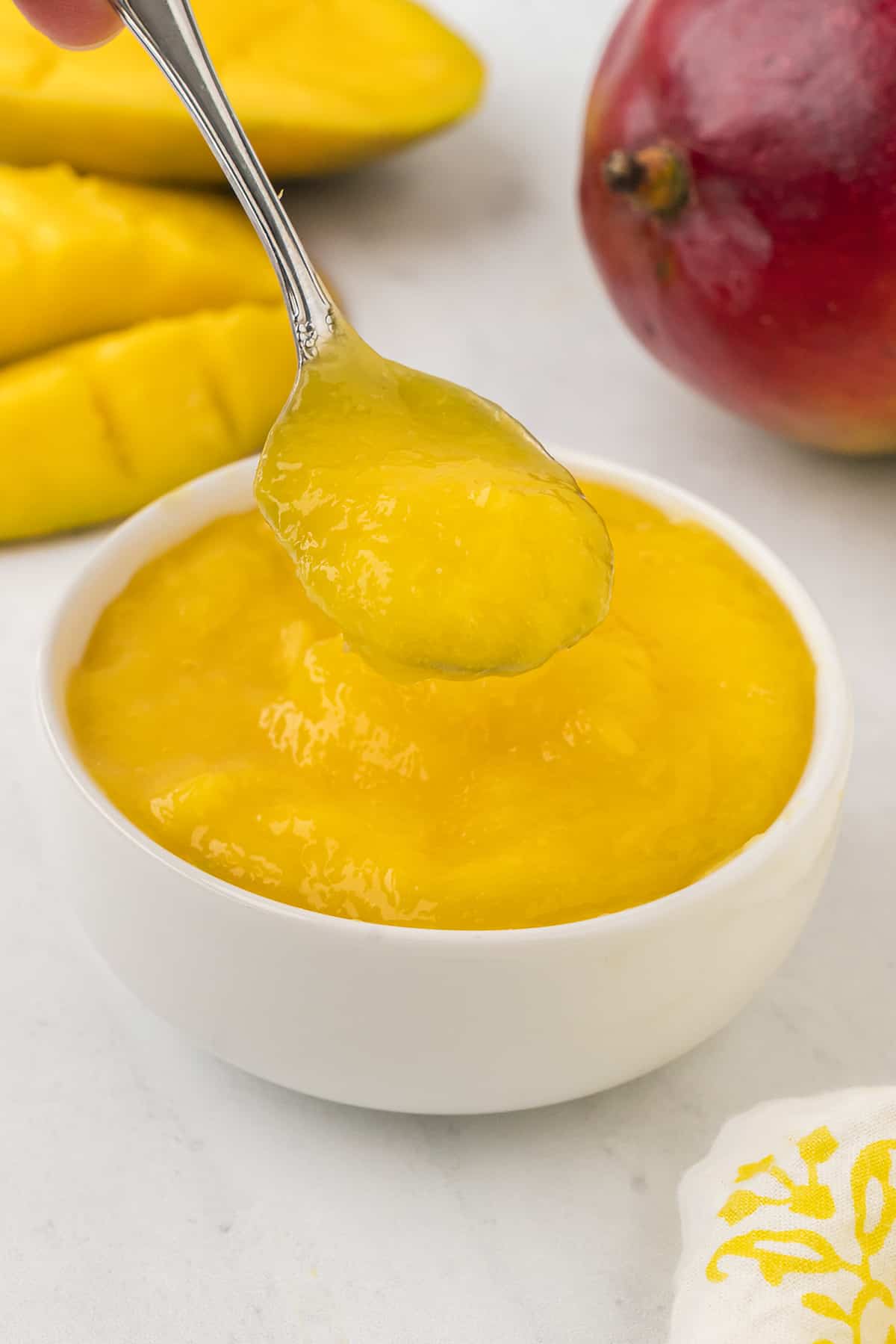 Mango puree in small white bowl.