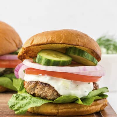 Greek turkey burger on wooden board.