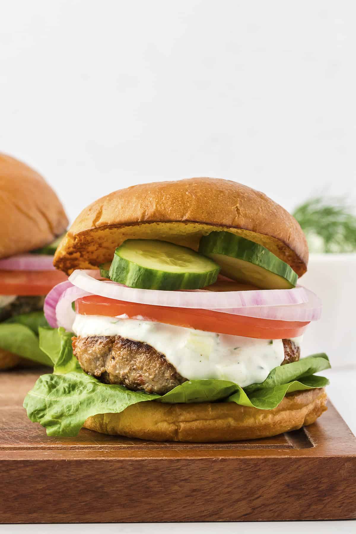 Greek turkey burger on wooden board.