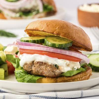 Greek turkey burger topped with tzatziki and fresh vegetables.