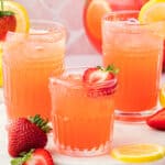 Three glasses of lemonade vodka with strawberries.
