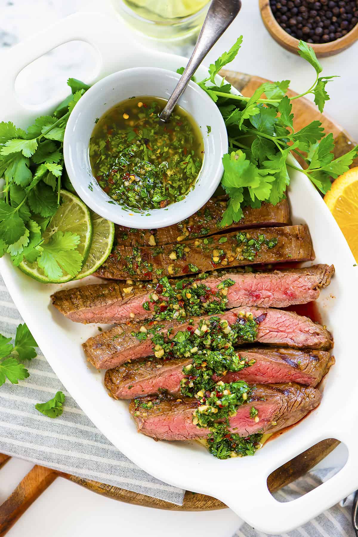 Flank steak sliced and drizzled with chimichurri.