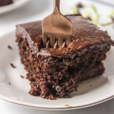 Slice of chocolate zucchini cake with a fork in it.