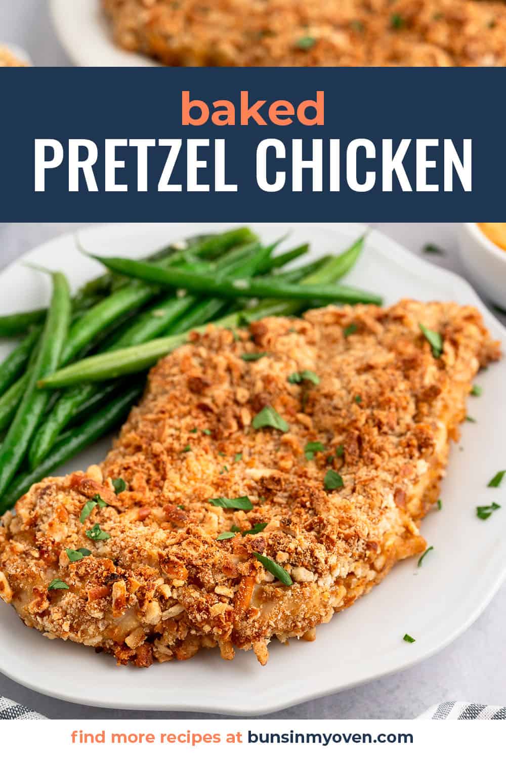 Pretzel chicken on white plate with green beans.