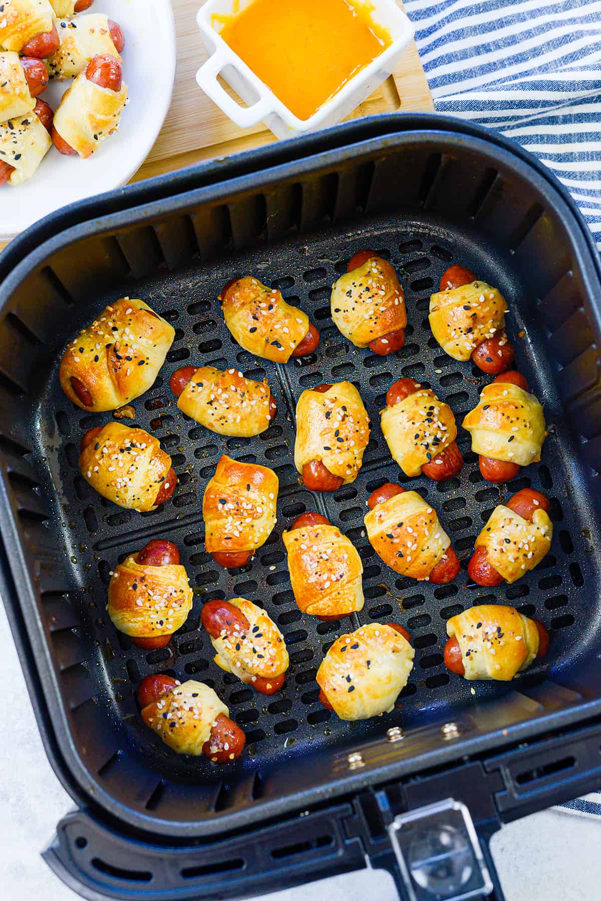 Mini pigs in a blanket in air fryer basket.