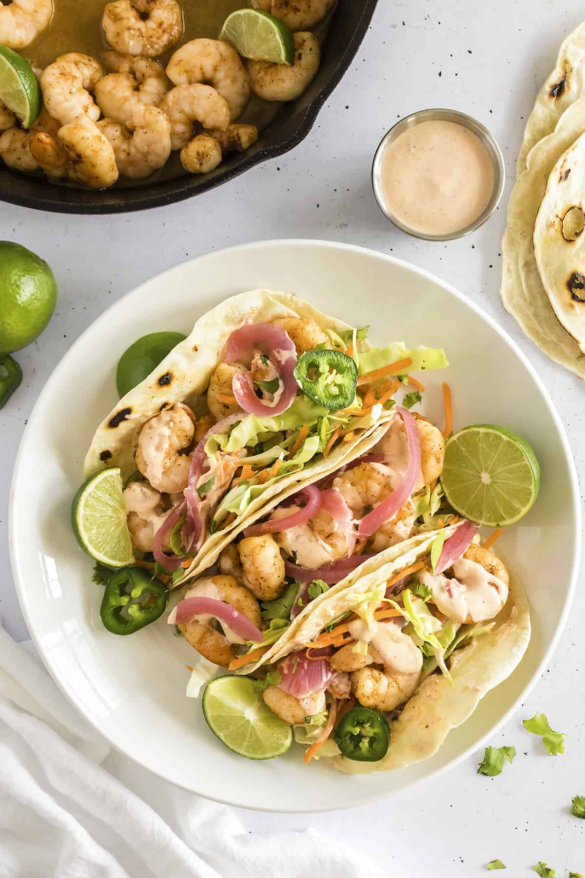Overhead view of shrimp tacos on plate.