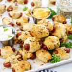 Mini pigs in a blanket piled together on baking sheet.