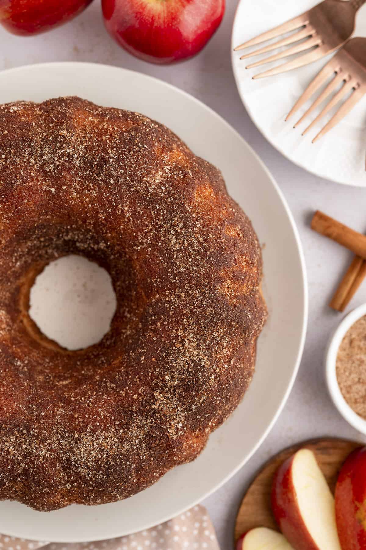 Apple cider donut cake on white cake plate.