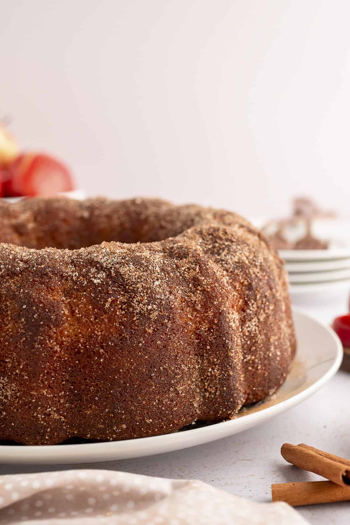 Apple cider donut cake on white cake plate.