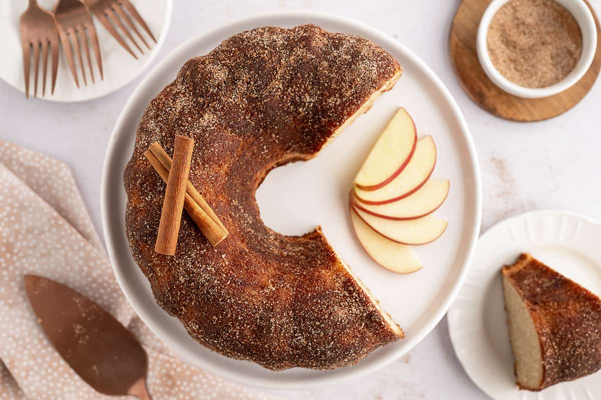 Overhead view of apple cider cake on whitep late.