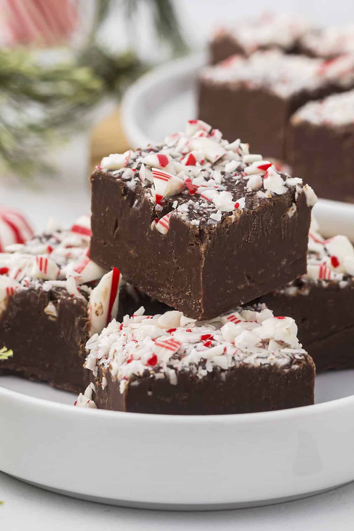 Peppermint fudge stacked on white plate.