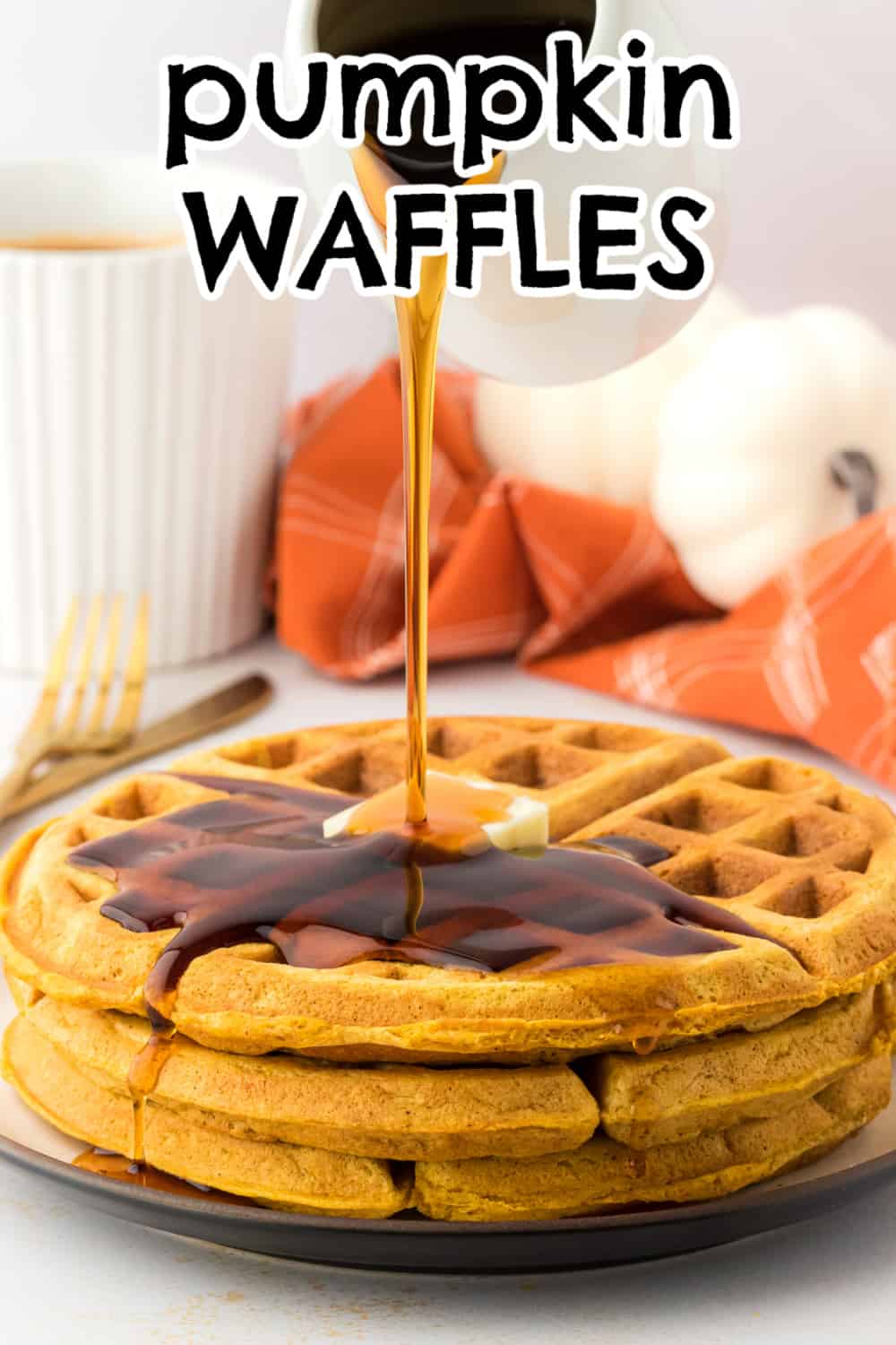 Syrup being poured over stack of pumpkin waffles.