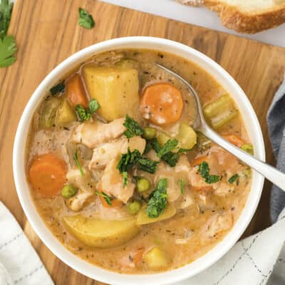 Overhead view of chicken stew in white bowl.