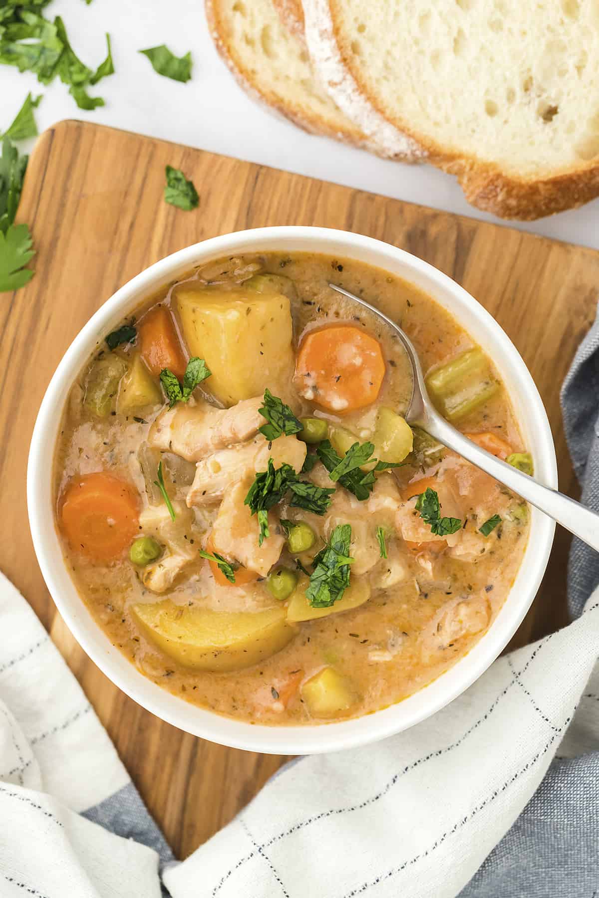 Overhead view of chicken stew in white bowl.