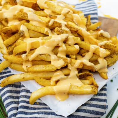 Cheese fries on white platter.