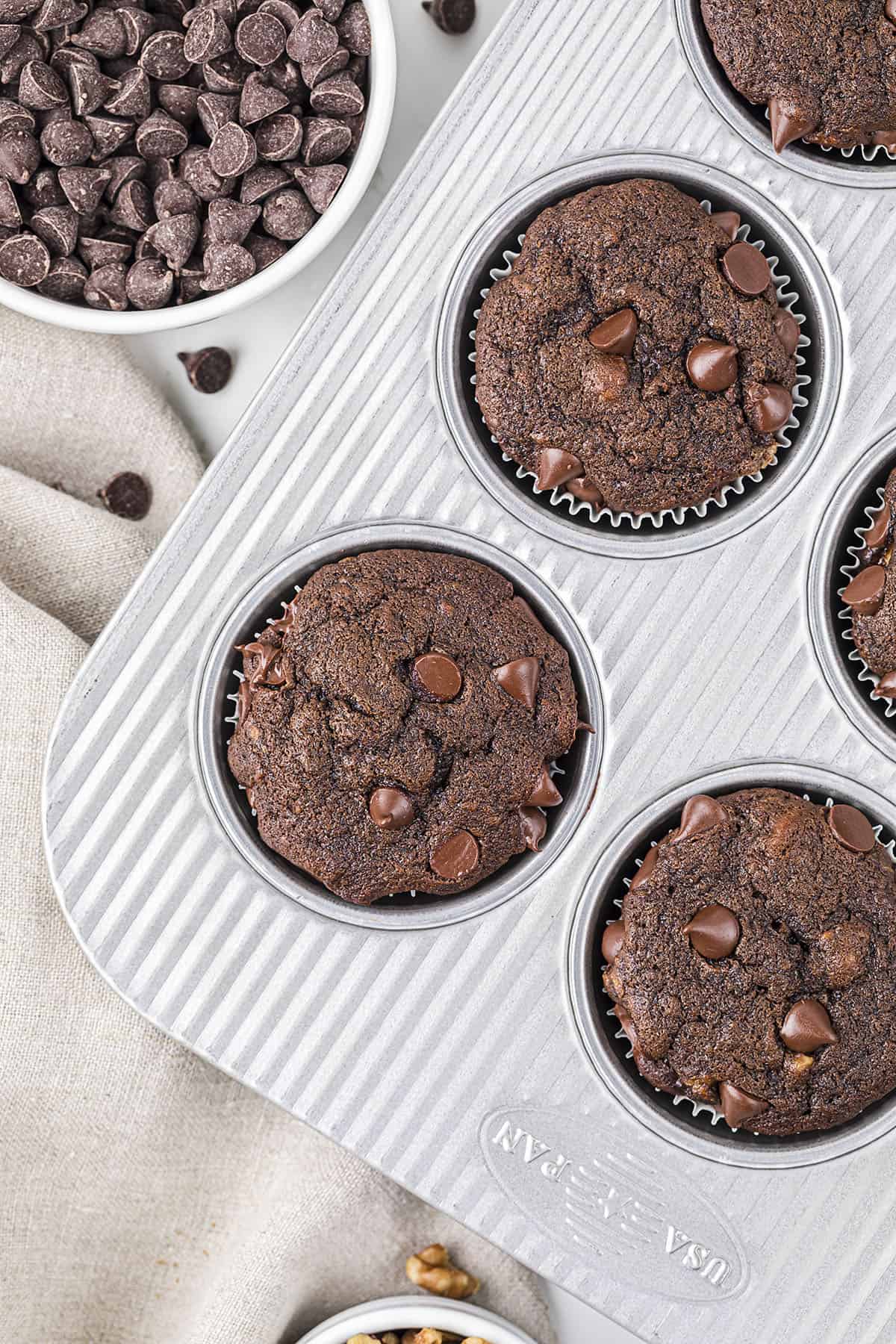 Baked chocolate banana muffins in muffin tin.