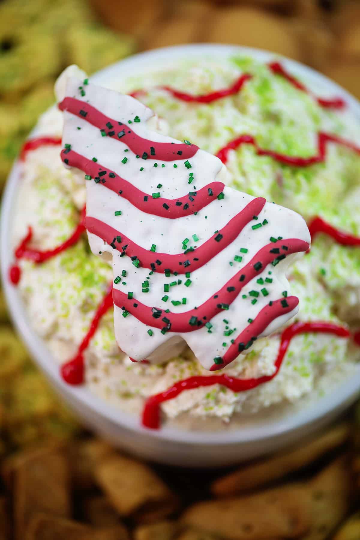 Christmas Tree Cake dip in white bowl surrounded by cookies.
