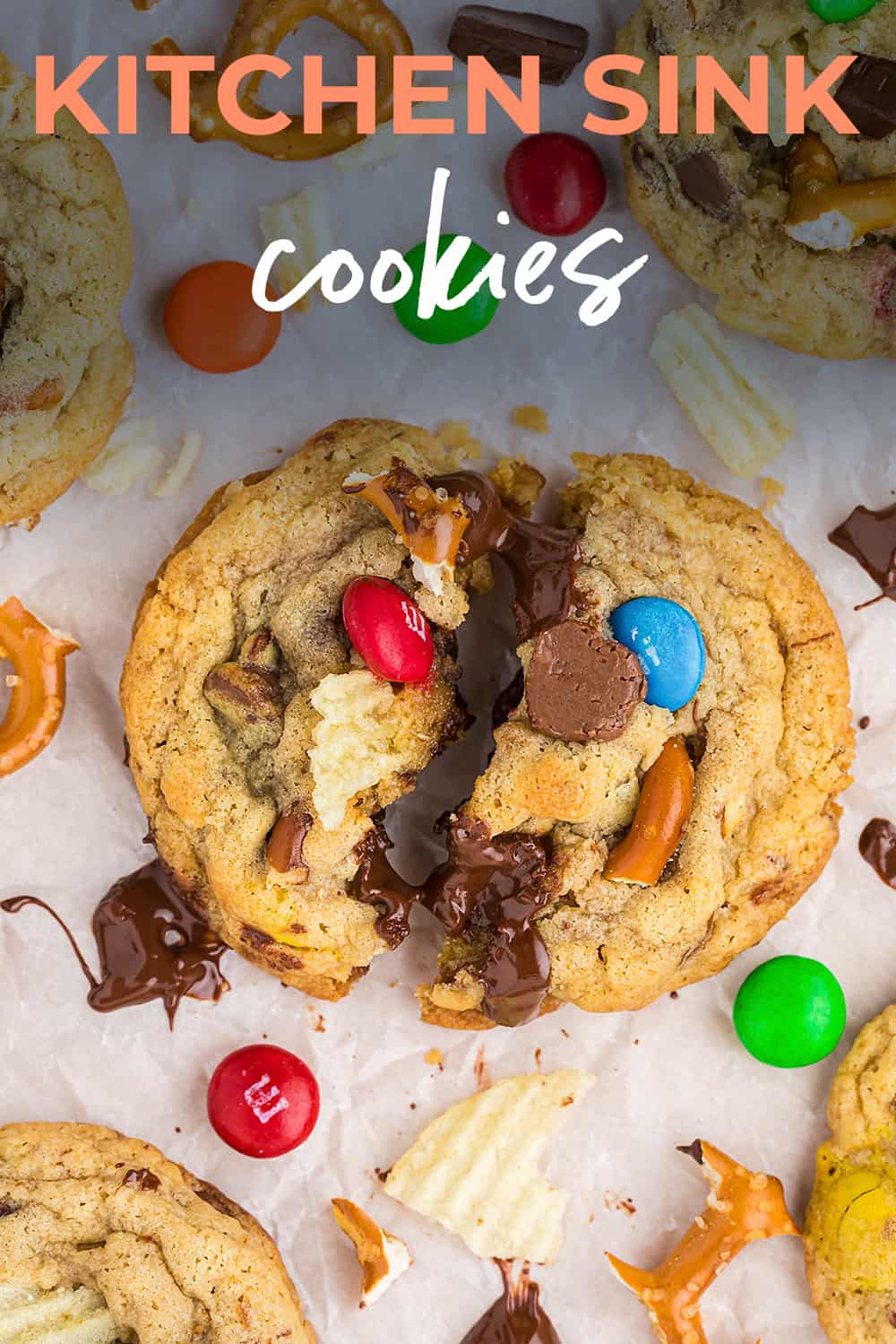 Cookie surrounded by m&ms, chocolate chips, and potato chips.