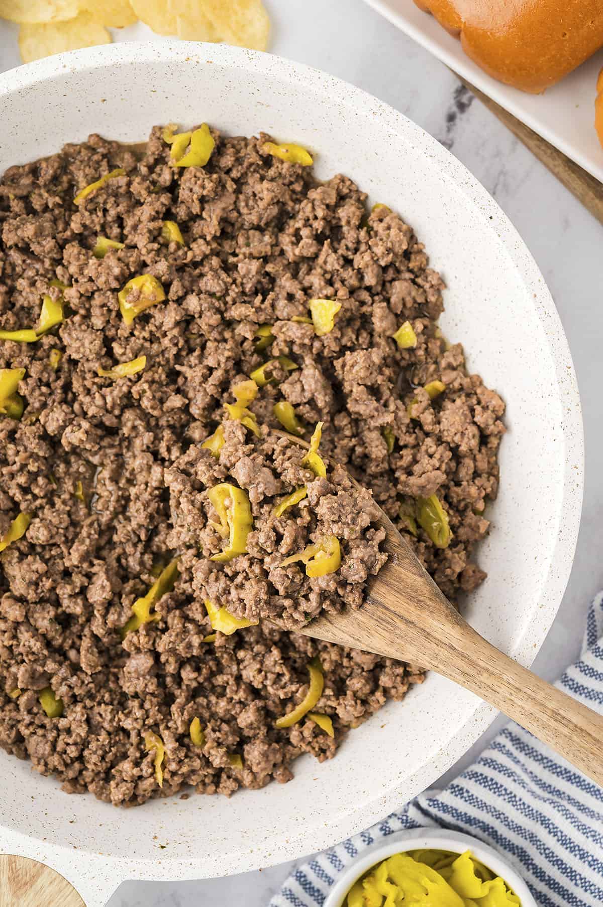 Ground beef with pepperoncini peppers in skillet.