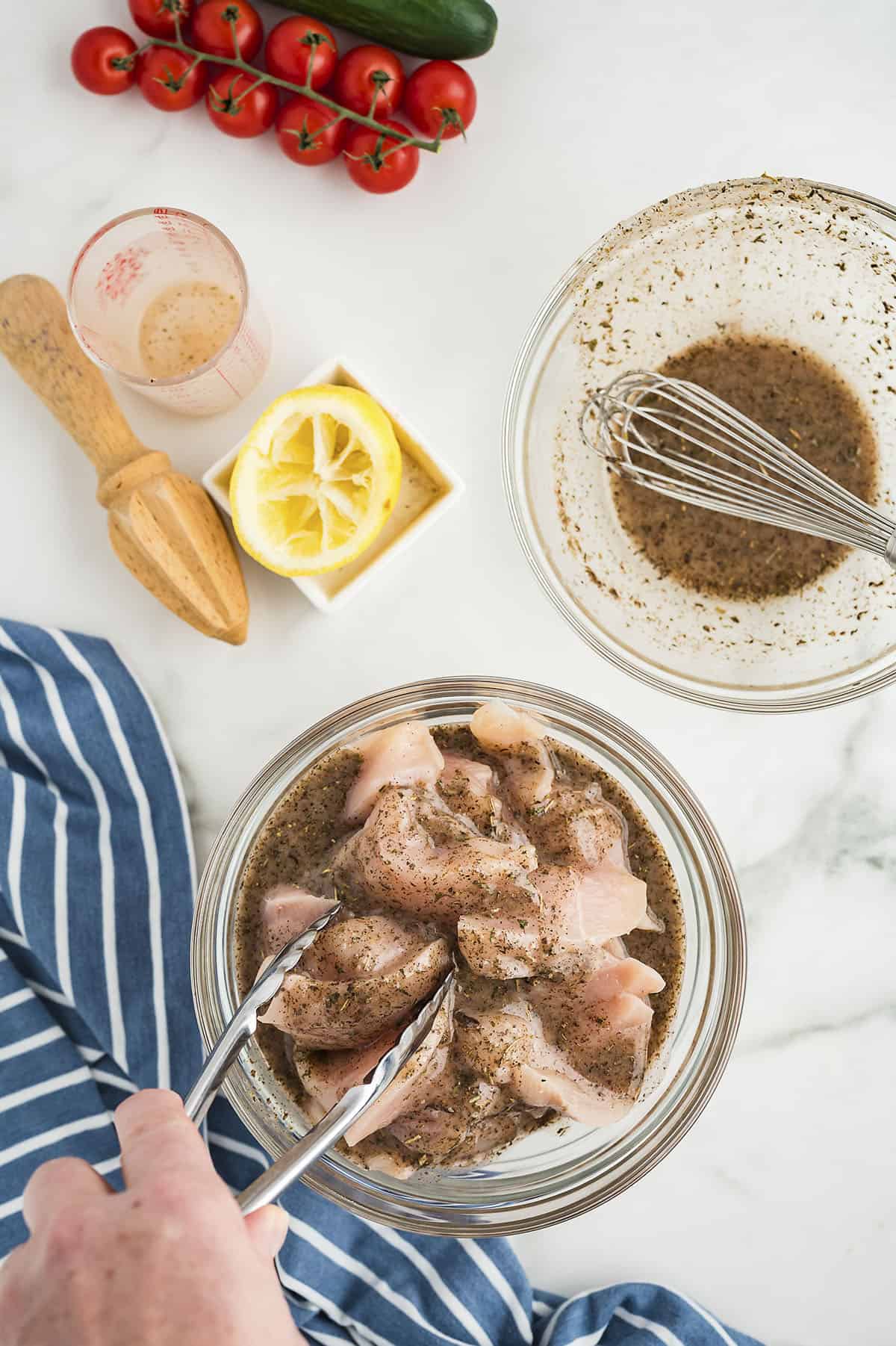 Chicken in a glass bowl of marinade.