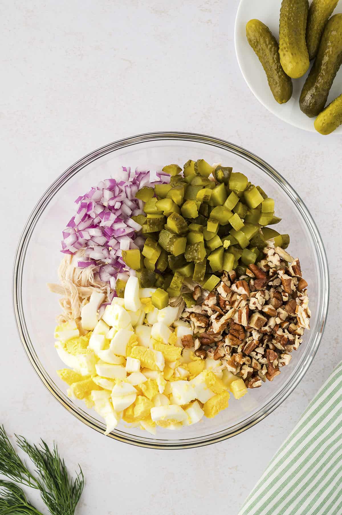 Ingredients for dill pickle chicken salad in glass mixing bowl.