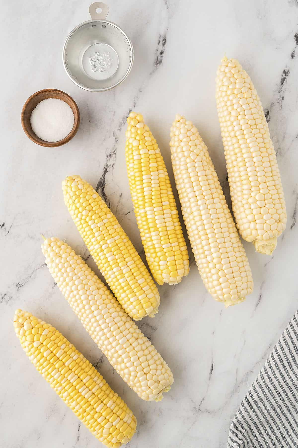 Corn on the cob laying on counter.