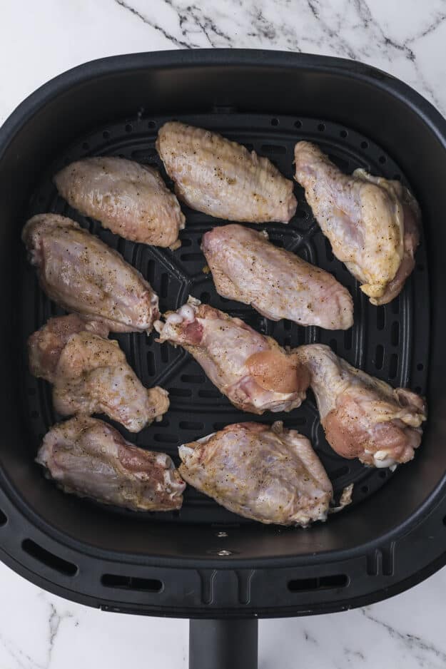 Chicken wings in air fryer basket.