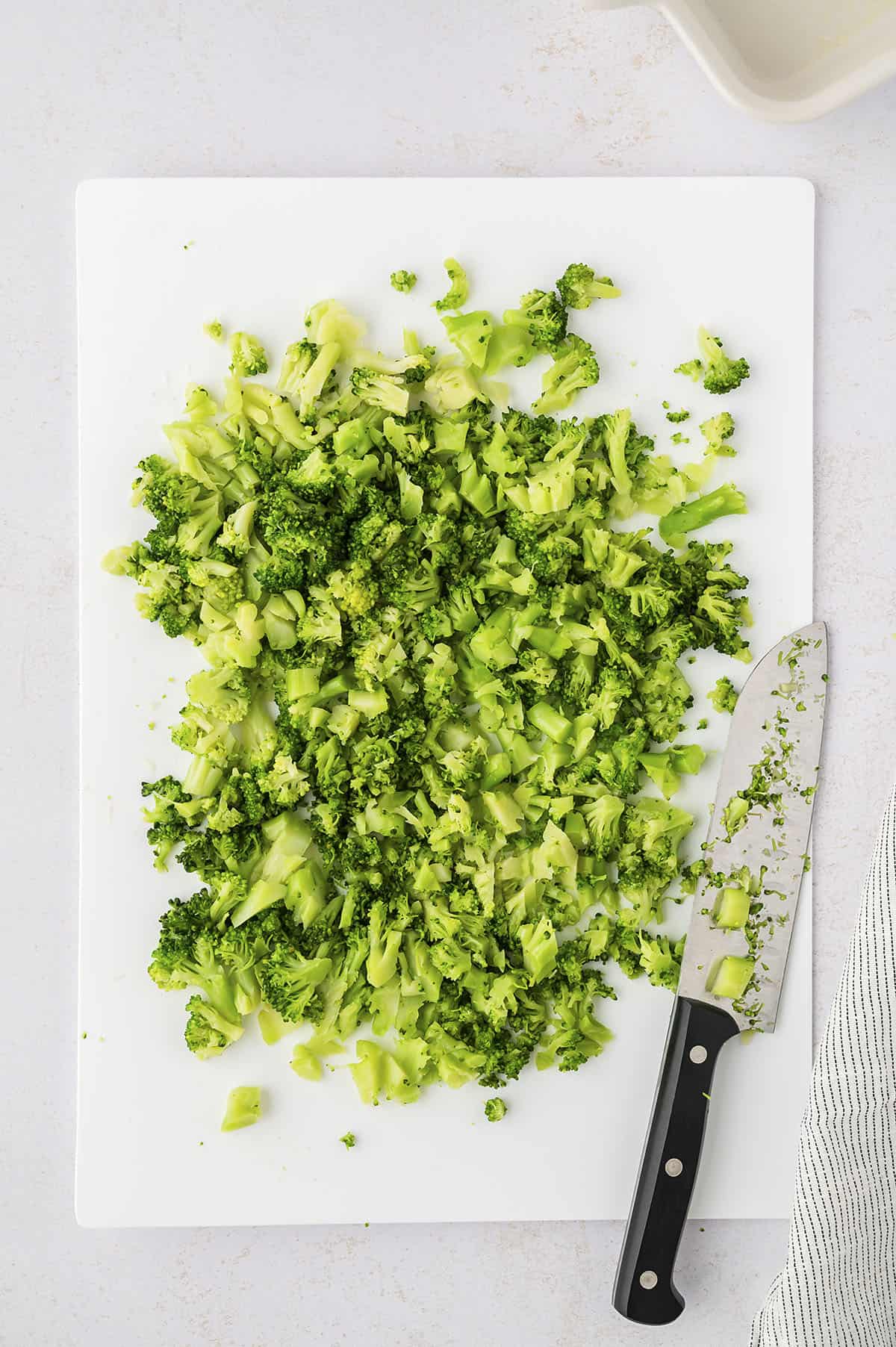 Finely chopped broccoli on a cutting board.