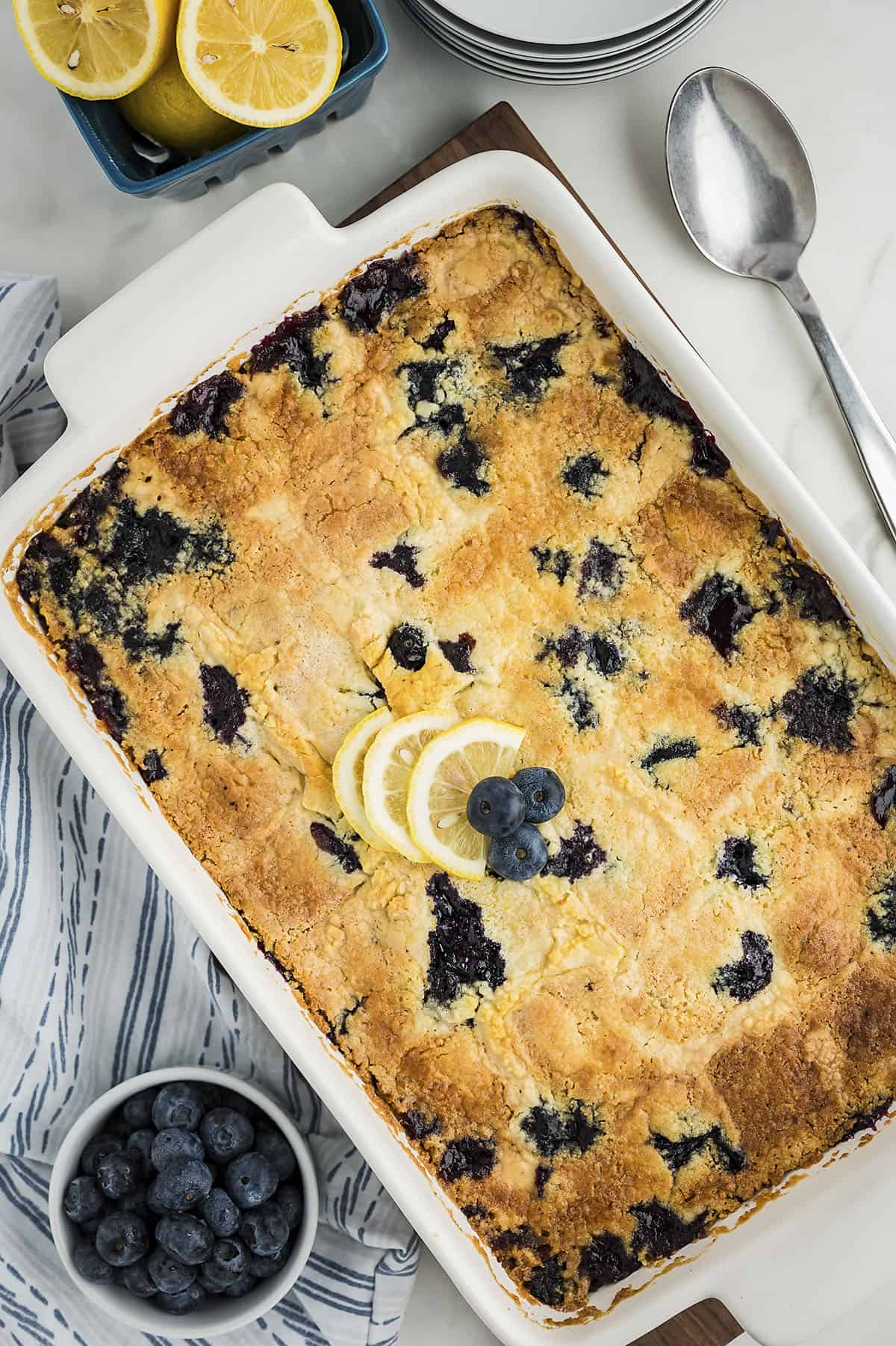 Baked lemon blueberry dump cake in white baking dish.